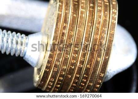 Tighten the Budget US Currency gold coins in a clamp vise