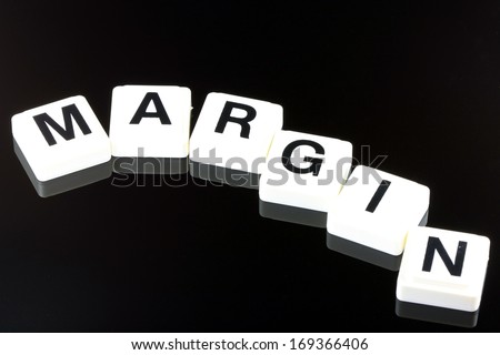 The Word Margin Spelled Out With White Tiles On Black Background - A Term Used For Business in Finance and Stock Market Trading