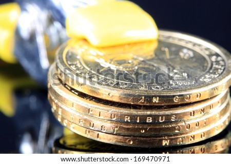 Money is Tight - Financial Concept US Currency gold coins in a tool clamp