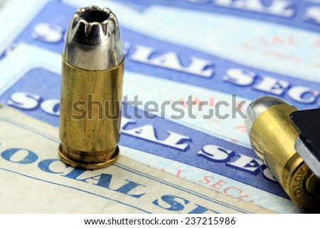 Ammunition bullets laying on social security card - The End or Death of social security benefits