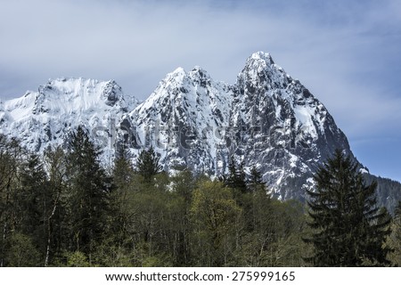 Mt Index, Washington - A spiky snow capped mountain peak surrounded by a forest wilderness