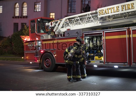 SEATTLE, WASHINGTON/USA - NOVEMBER 9, 2015: Firefighters check their oxygen tanks after a basement fire on the corner of Boylston Ave E and Lynn St in the Eastlake Neighborhood