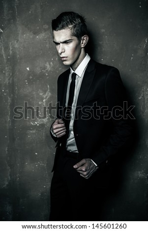 Strong businessman with grey wall on the background