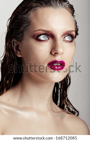 Hot young woman model with sexy bright red lips makeup, strong eyebrows, clean shiny skin and wet hairstyle. Beautiful fashion portrait of glamour female face