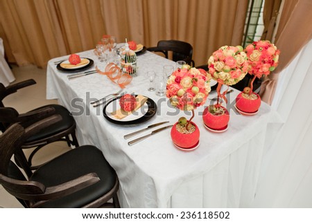Table set for 4 people. Orange decor and flowers