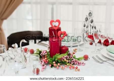 Candles with heart on laid table in a restaurant on Valentine\'s Day