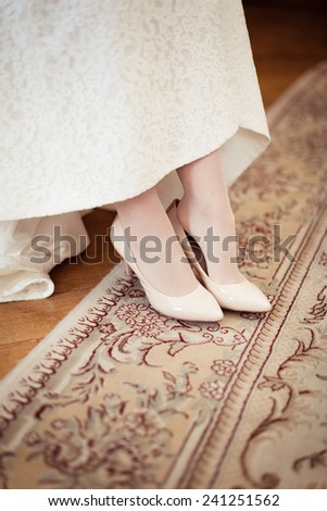 Bride dresses shoes before the wedding ceremony