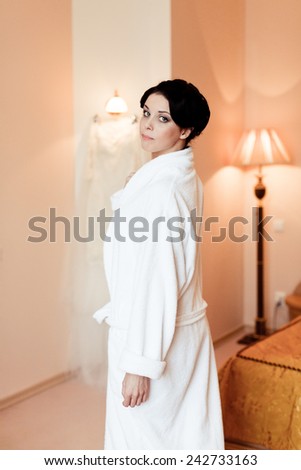 Beautiful happy bride in white silk lingerie in her bedroom in a morning