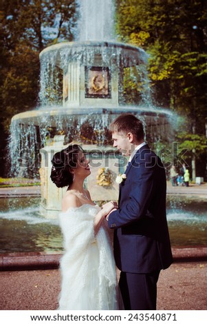 Bride and groom against fountain
