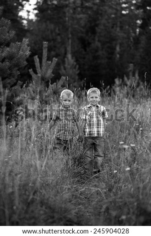 Two brothers hugging each other outdoor, smiling and laughing