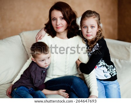 Mom with her two children sitting on the couch at home