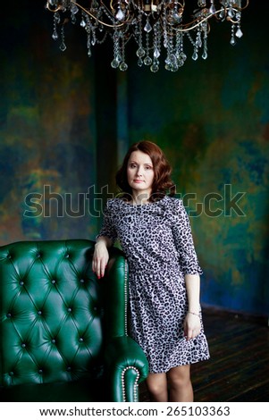 Woman in a leopard print dress near the chair