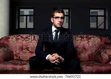 Stylish man in suit and glasses sitting