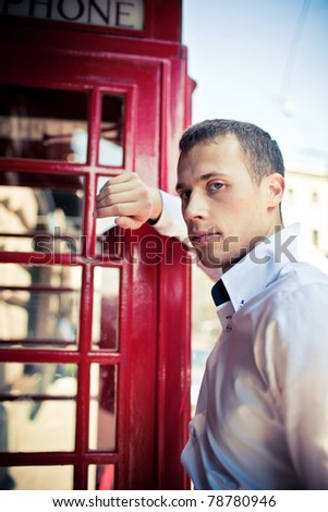 man next to the typical red London phone boot