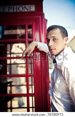 man next to the typical red London phone boot