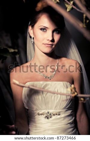stock photo Portrait of a woman in a wedding dress among the branches