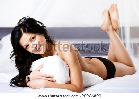stock photo smiling naked young woman lying on white sheet