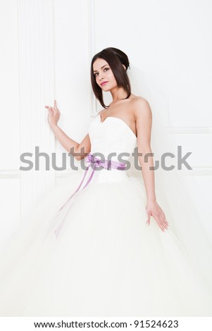 Cute girl in a gorgeous wedding dress with a ribbon