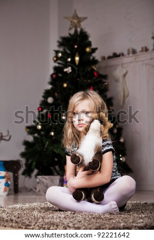 Little girl under the tree with gifts
