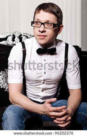 Man with a bow tie sitting on the couch