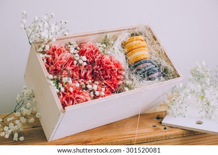 Carnation flowers in a box with a macaroon