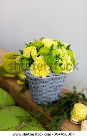 Beautiful bouquet of yellow carnation in basket on bright background