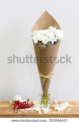 Paper cornet with a bouquet of white chrysanthemum in a glass vase. Hooray! First grade