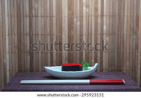 Sushi put into Small plates with bamboo mat background. Focus on Sushi. Design with space for adding text or montage of your product. Sushi  is a Japanese food consisting of cooked rice.
