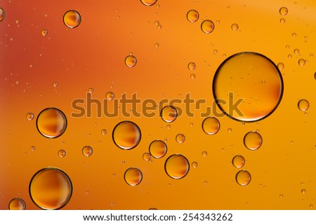 Oil and water abstract in yellow, gold and orange, giving the impression of rising bubbles, unfocused