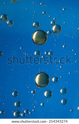 Oil and water abstract in blue and gold, giving the impression of rising bubbles