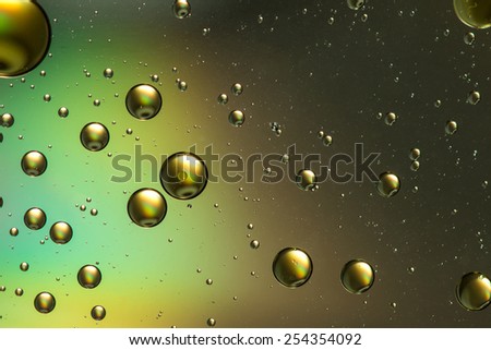 Gold and brown oil and water abstract with a rainbow effect giving the impression of planets