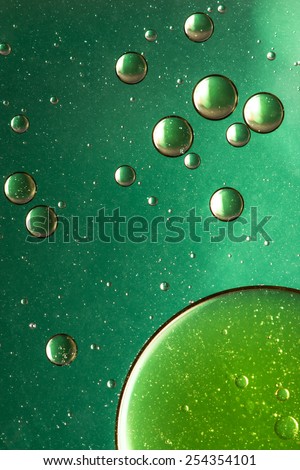 Green and gold oil and water abstract, giving the impression of rising bubbles