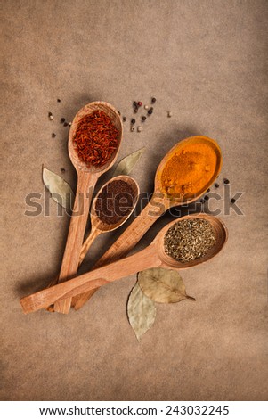 wooden spoon with spices on brown background