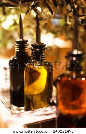 bottles of oil with tips standing on wooden table with oil tree