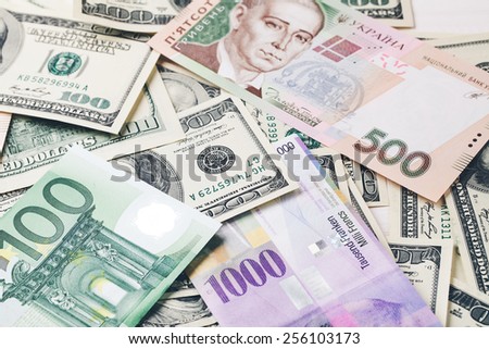 Money: dollars, UAH, the euro , and Swiss francs lying on white wooden table in a row