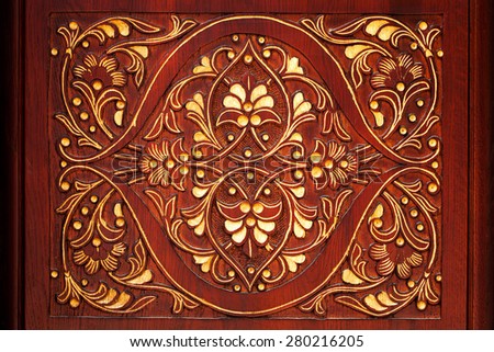 Carved pattern on a dark background with a floral theme