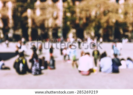 Street cafe in Barcelona with square metal table and wicker chairs on the background of blurred street with people