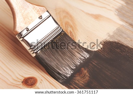 Grey color painting on wooden table or fence or wall, or flour, use for home decorated. House renovation. Half - painted surface. Smear of paint brush. Macro.