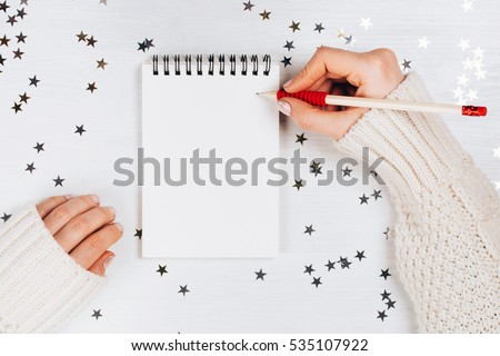 Holiday decorations and notebook with wish list on white rustic table, flat lay style. Planning concept.
