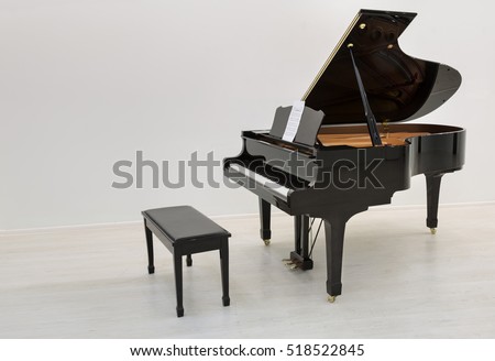 Black piano is ready to play in a white room