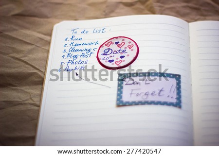 Notebook page with to do list and stickers. Selective focus on the sticker Date. With shallow depth of field.