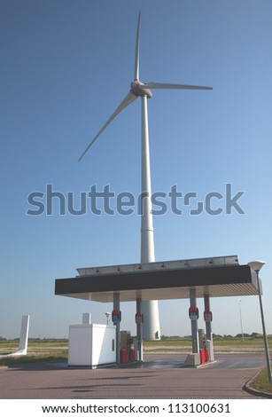 Wind turbine and gas station with a clear blue sky