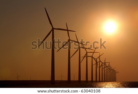 Silhouette of windmills with a sunset