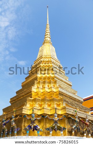 Colorful Guardian Statues Around the Base of a Shimmering Gold Chedi at the Grand Palace and Temple of the Emerald Buddha in Bangkok, Thailand