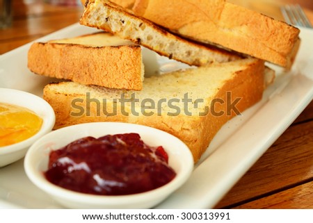 Slices of toasted bread served with preserves on a rectangular plate. Selective focus