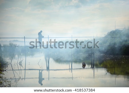 Buddhist monks on wooden bridge in fog