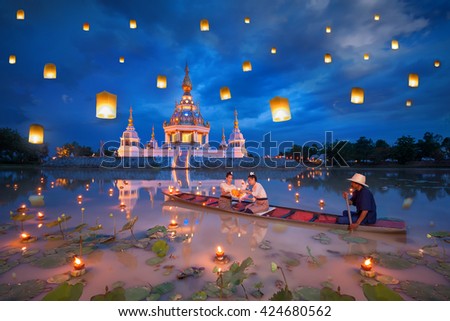 Woman on boat for kratong and floating lamp festival in pagoda background