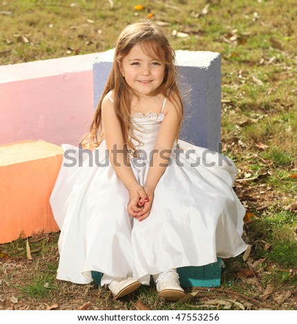 stock photo Beautiful young blonde girl sitting on colorful cube with 