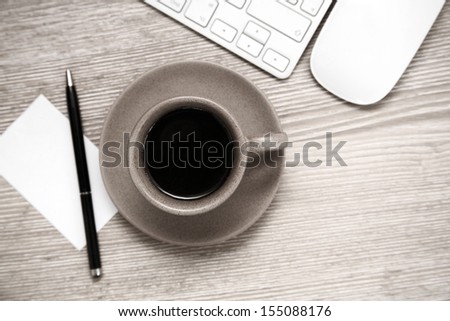 Toned image, cup of black coffee, pen, blank sheet of paper, mouse and  keyboard on wooden table