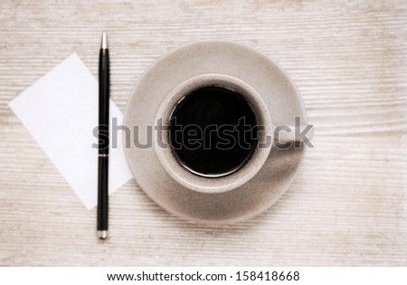 Artwork in painting style, cup of black coffee, pen and blank sheet of paper on wooden table